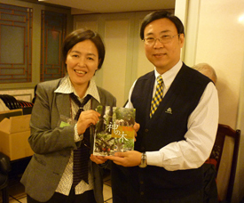 行政院農業委員会林業試験所の黄裕星所長（右）に、自著『神の木』を手渡す李春子氏（左）
